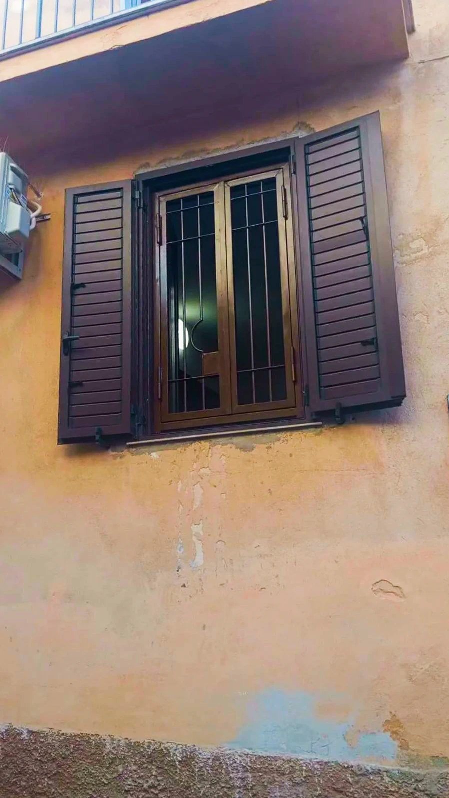 Finestra con persiane e grata