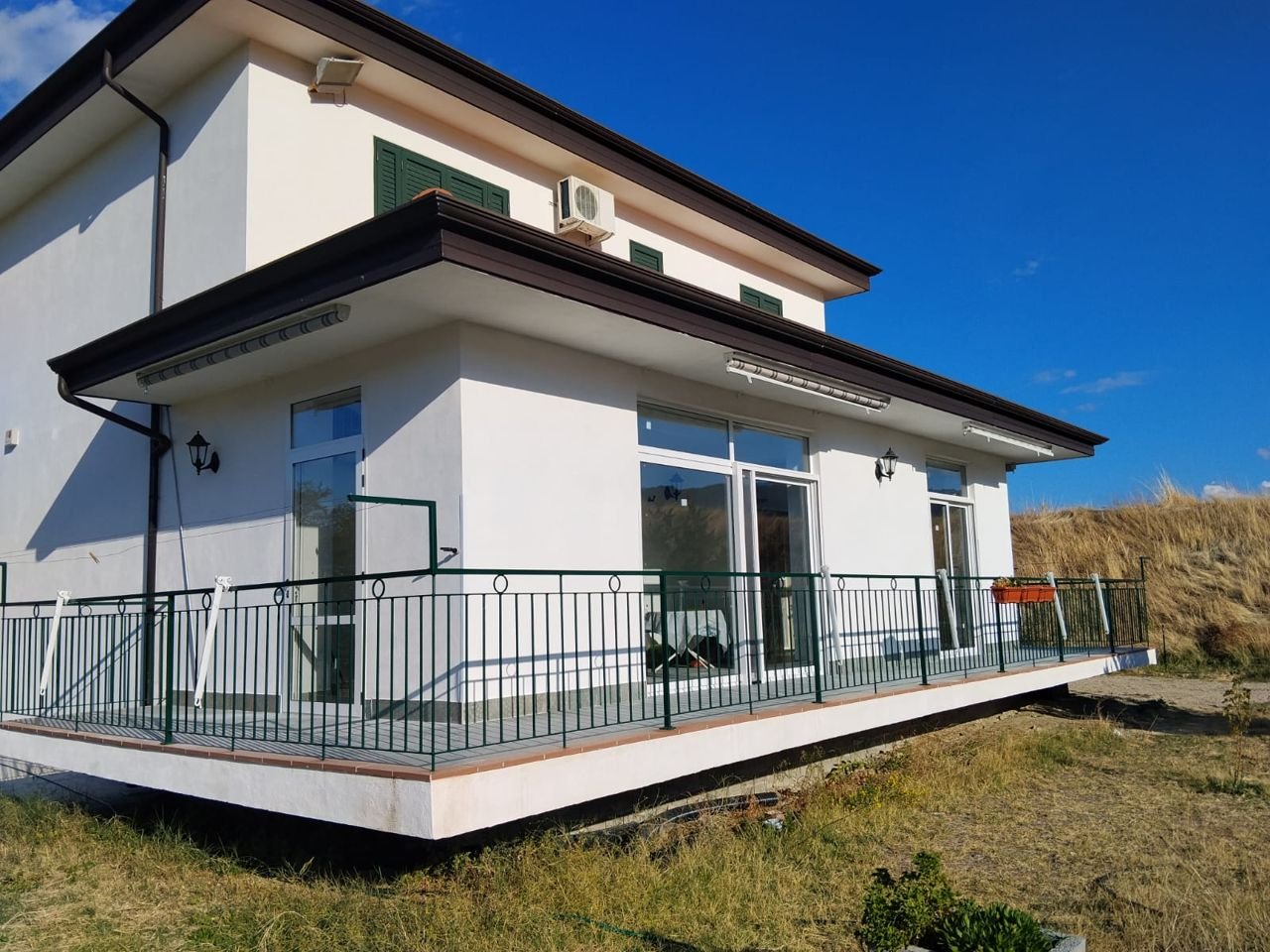 Infissi in alluminio e ringhiera in ferro verde su terrazza