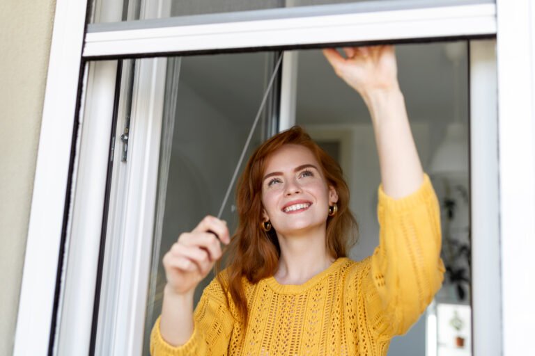 Woman hand hold retractable pleated insect screen holder to open or close the window ,mosquito nets